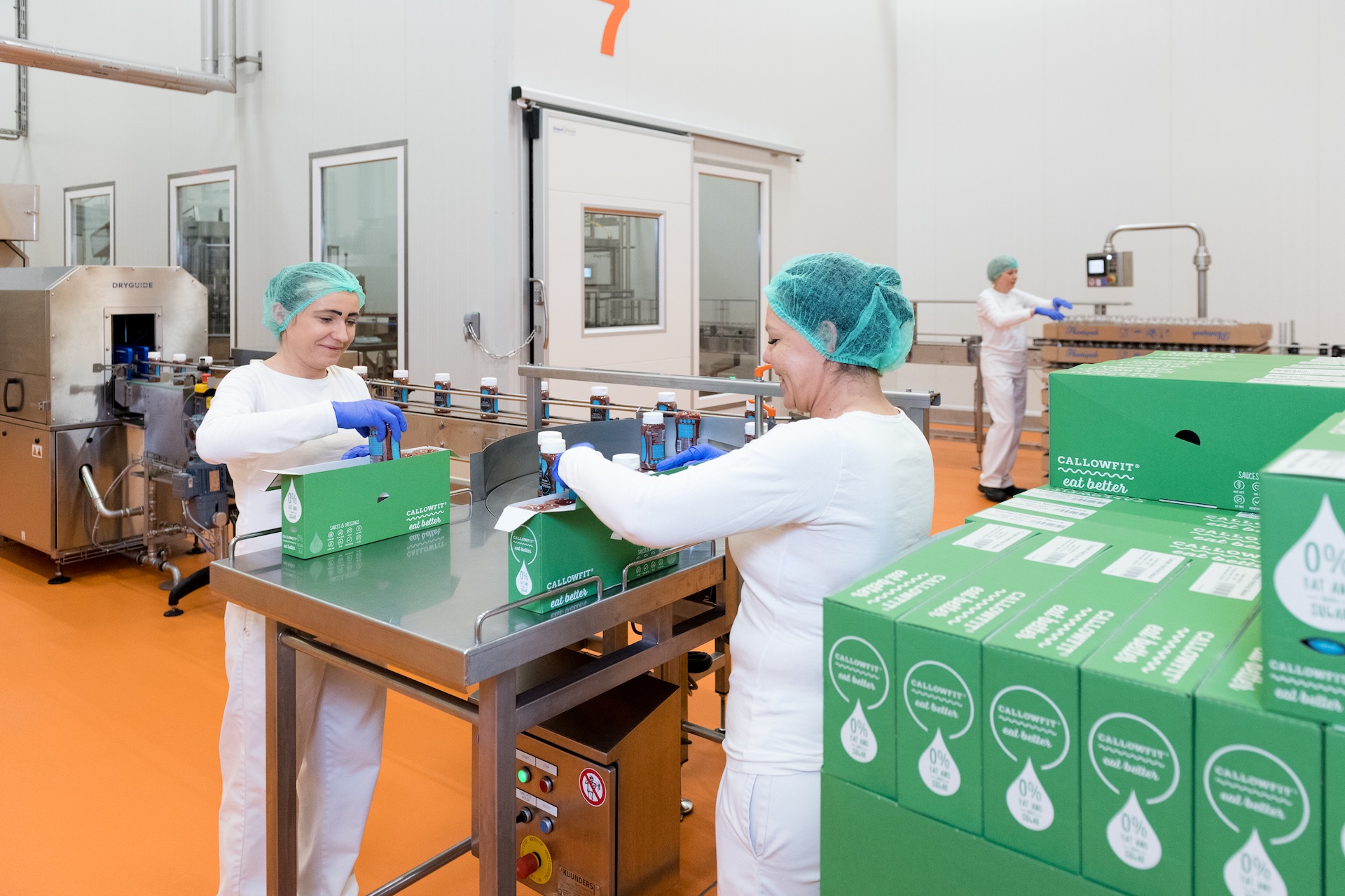 Twee medewerkers verpakken dozen in productiehal.