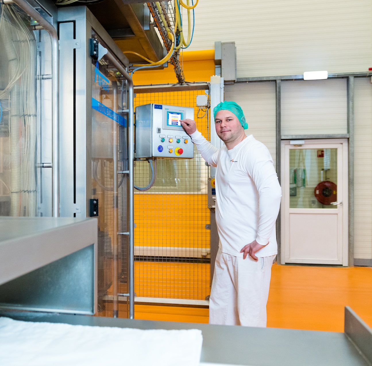 Productiemedewerker in hygiënekleding in fabriekshal.