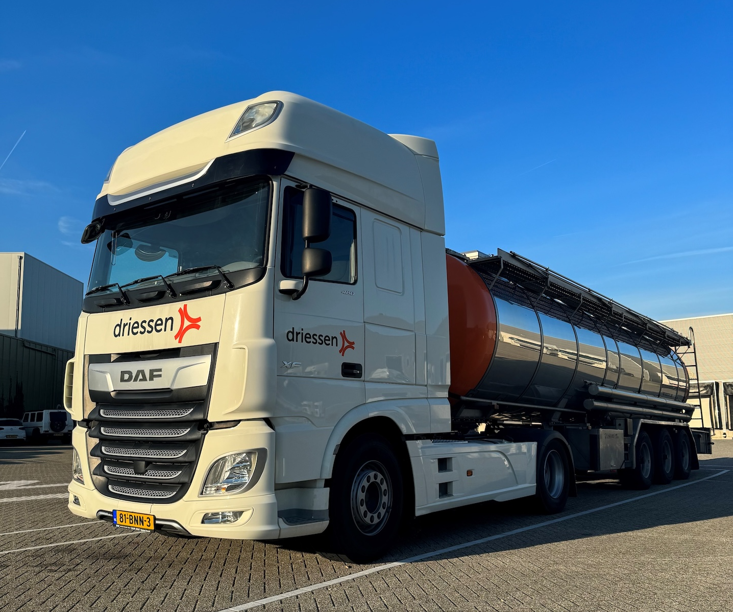 Medewerker voor vrachtwagen op bedrijfsterrein.
