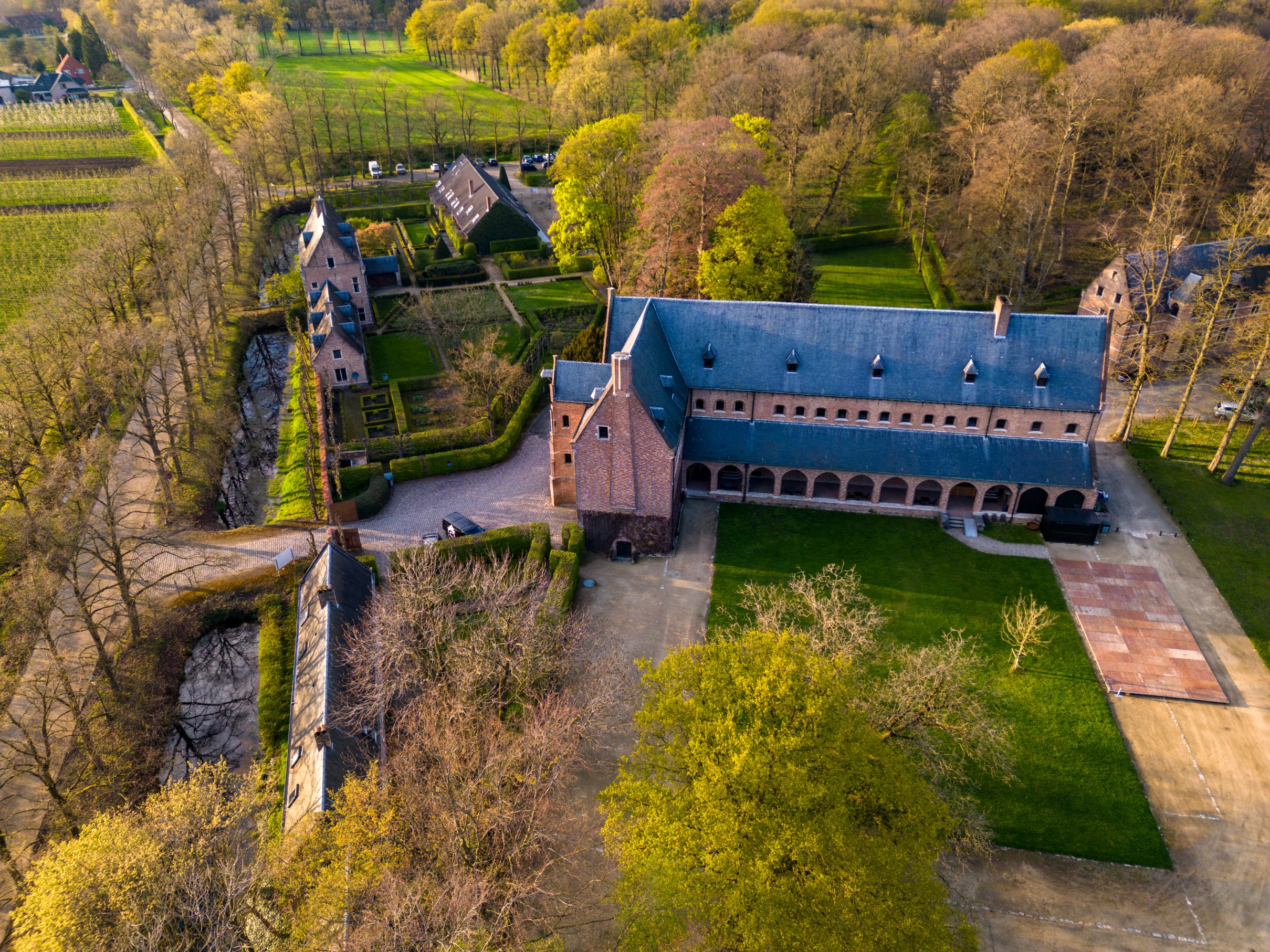 The historic monastery building of Priorij Corsendonk surrounded by verdant grounds