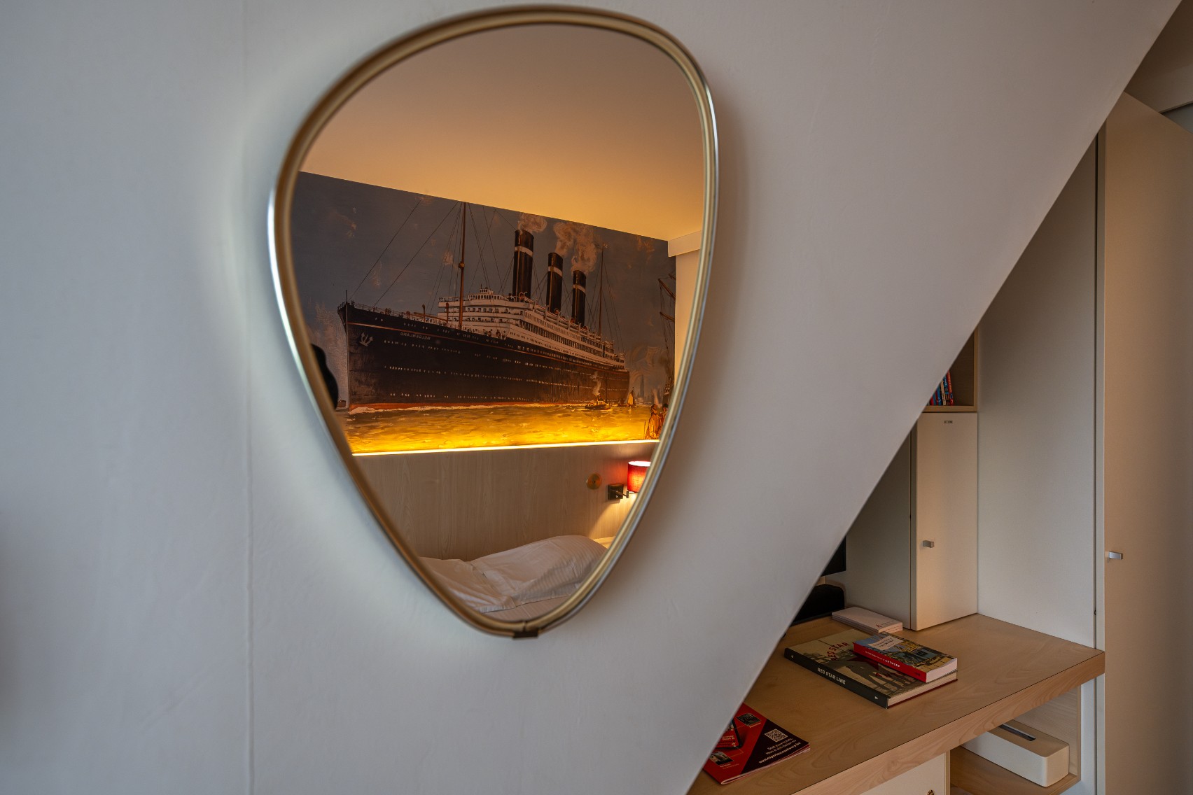 Mirror reflecting the ship artwork with warm amber backlight