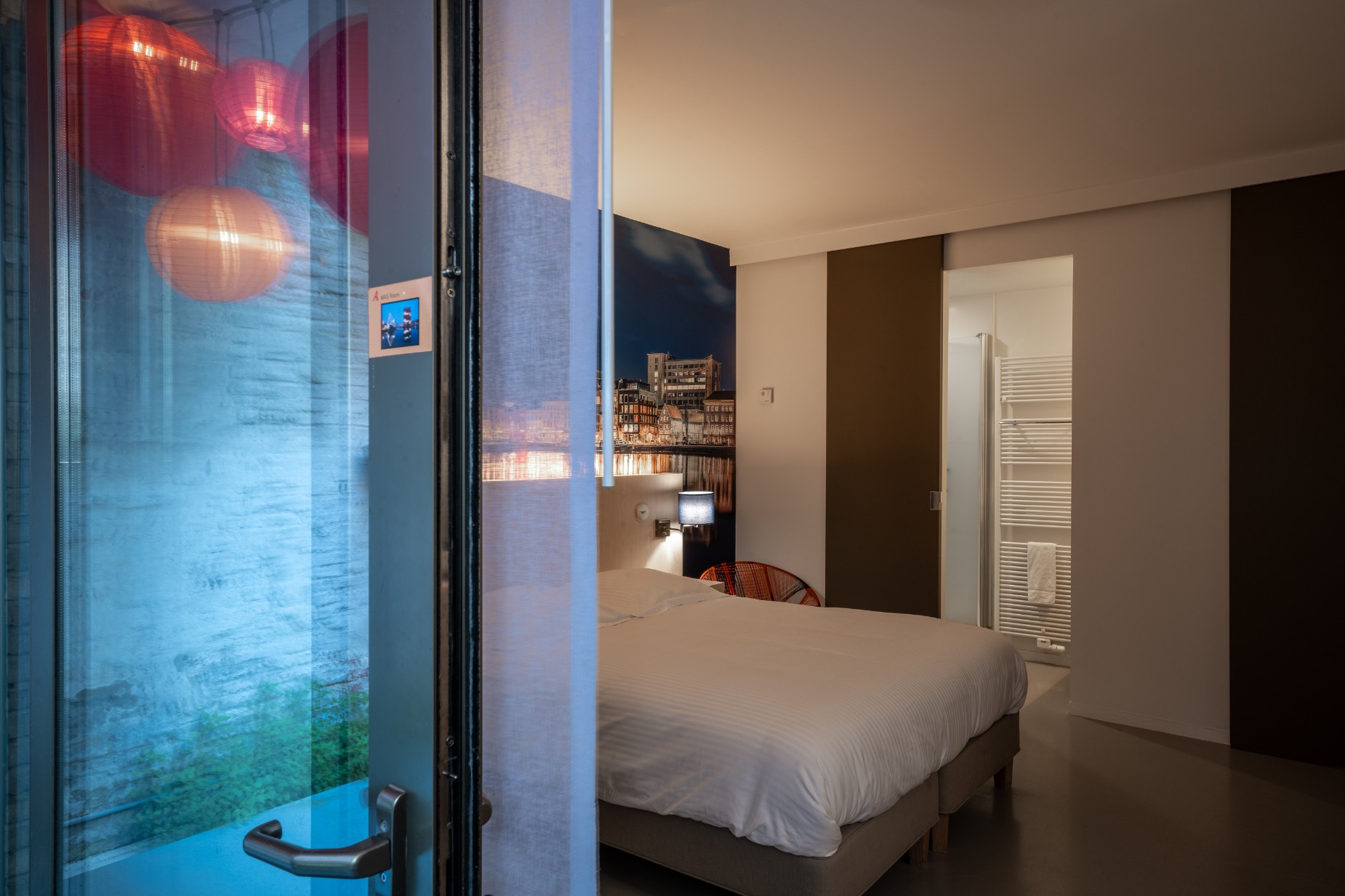 MAS Room bedroom and ensuite bathroom with neon artwork above the bed