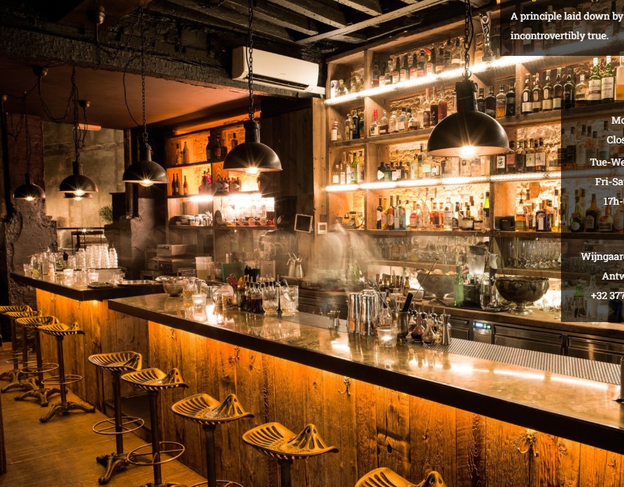 Well-stocked bar with shelving, pendant lighting, wooden counter and industrial aesthetic interior.