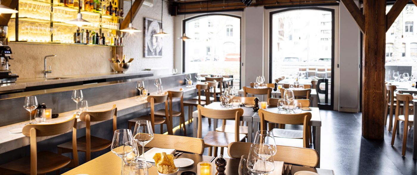 Restaurant interior with wooden chairs and open kitchen