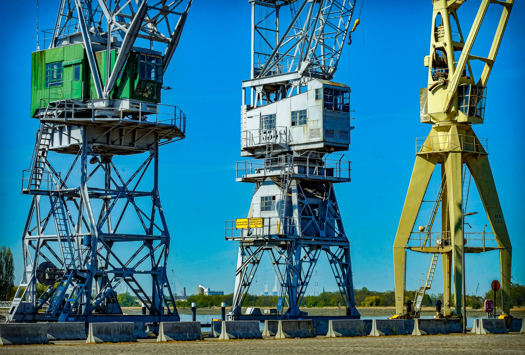 Industrial harbour cranes against a clear blue sky