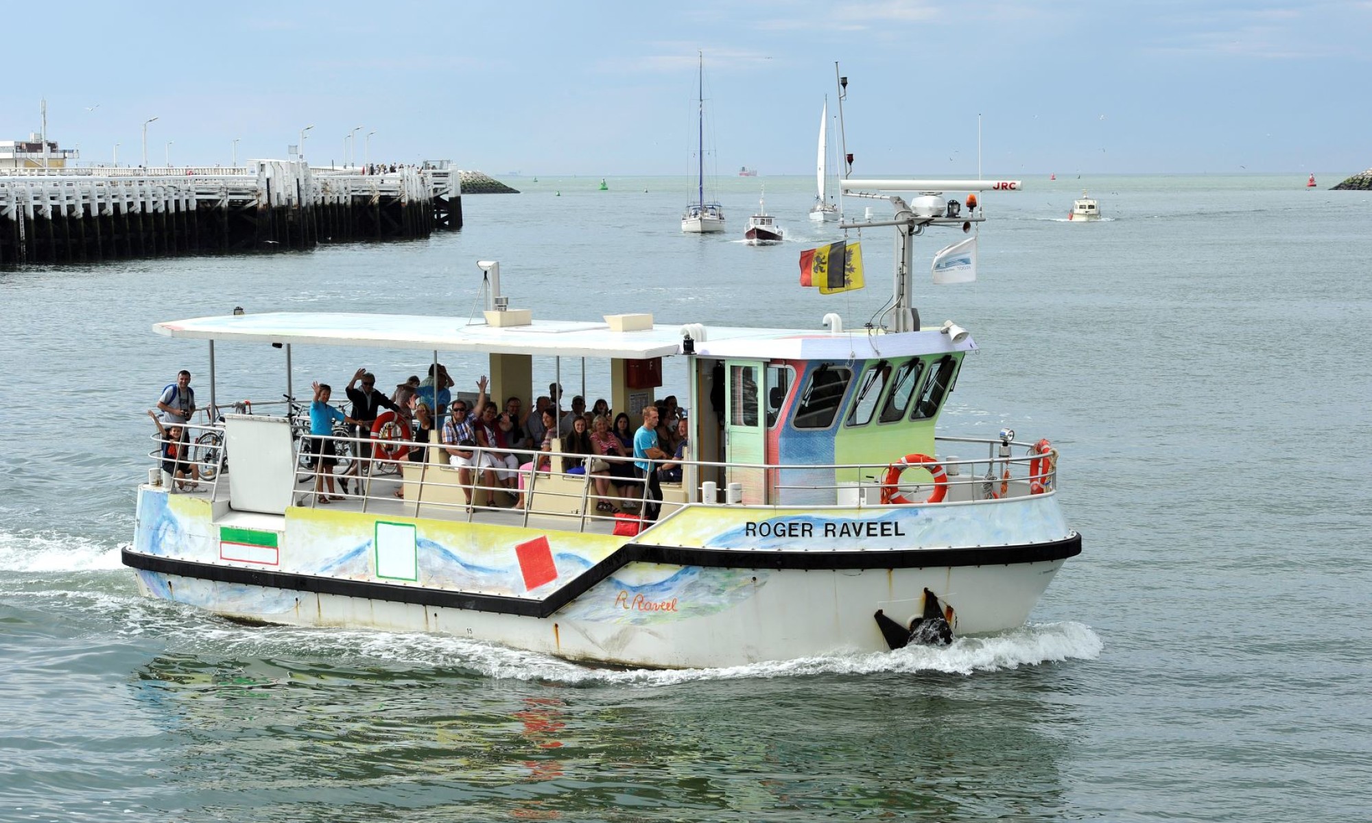 Colourful ferry moored at the beach with visitors on board