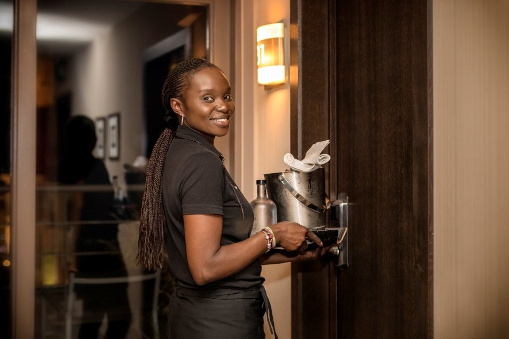 Een medewerker brengt champagne en een ijsemmer naar de kamer
