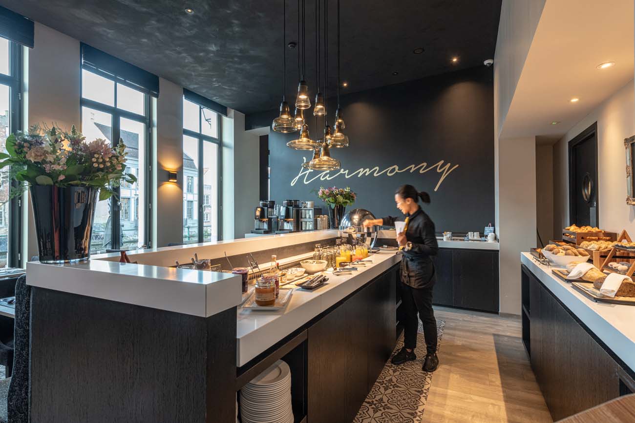 Ontbijtruimte van Hotel Harmony met verse koffiekoeken en bloemen