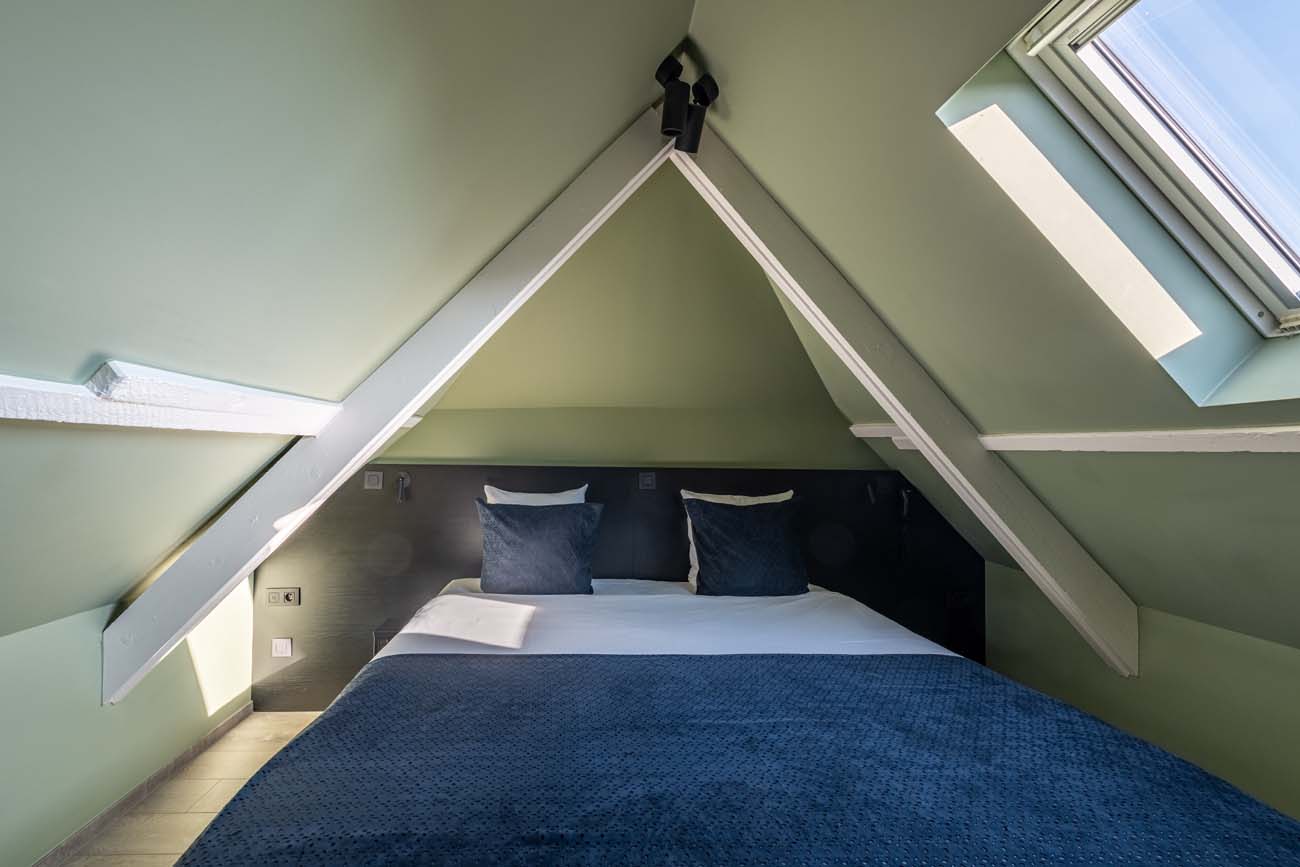 Cosy kamer onder het dak met schuin plafond en dakraam