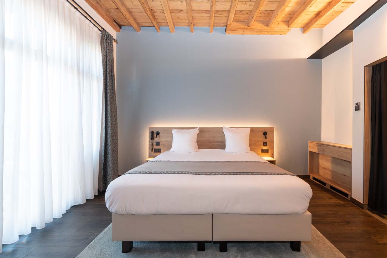 Luxe dubbele kamer met houten balken en verlicht hoofdeinde