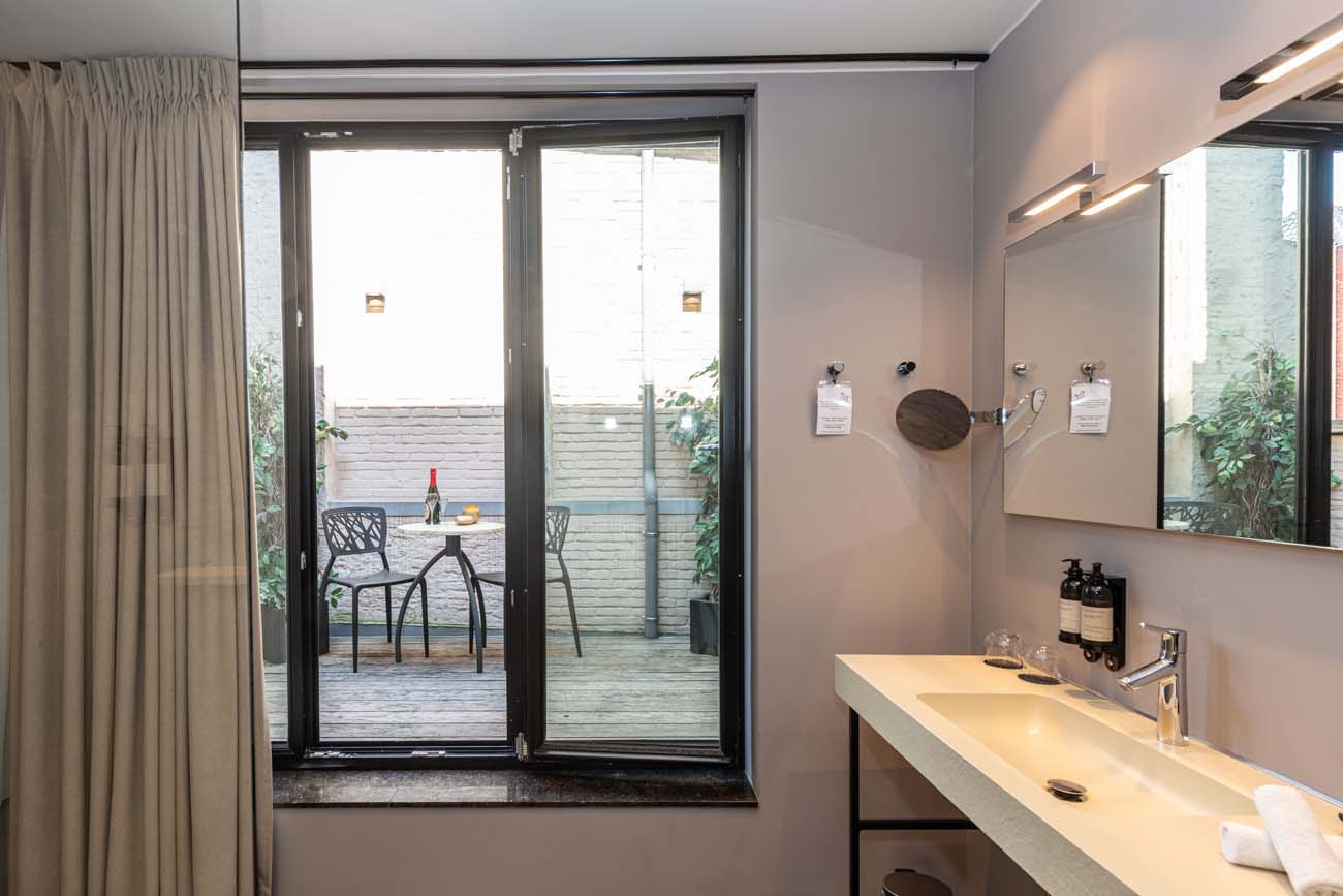Badkamer met glazen deuren en zicht op het terras