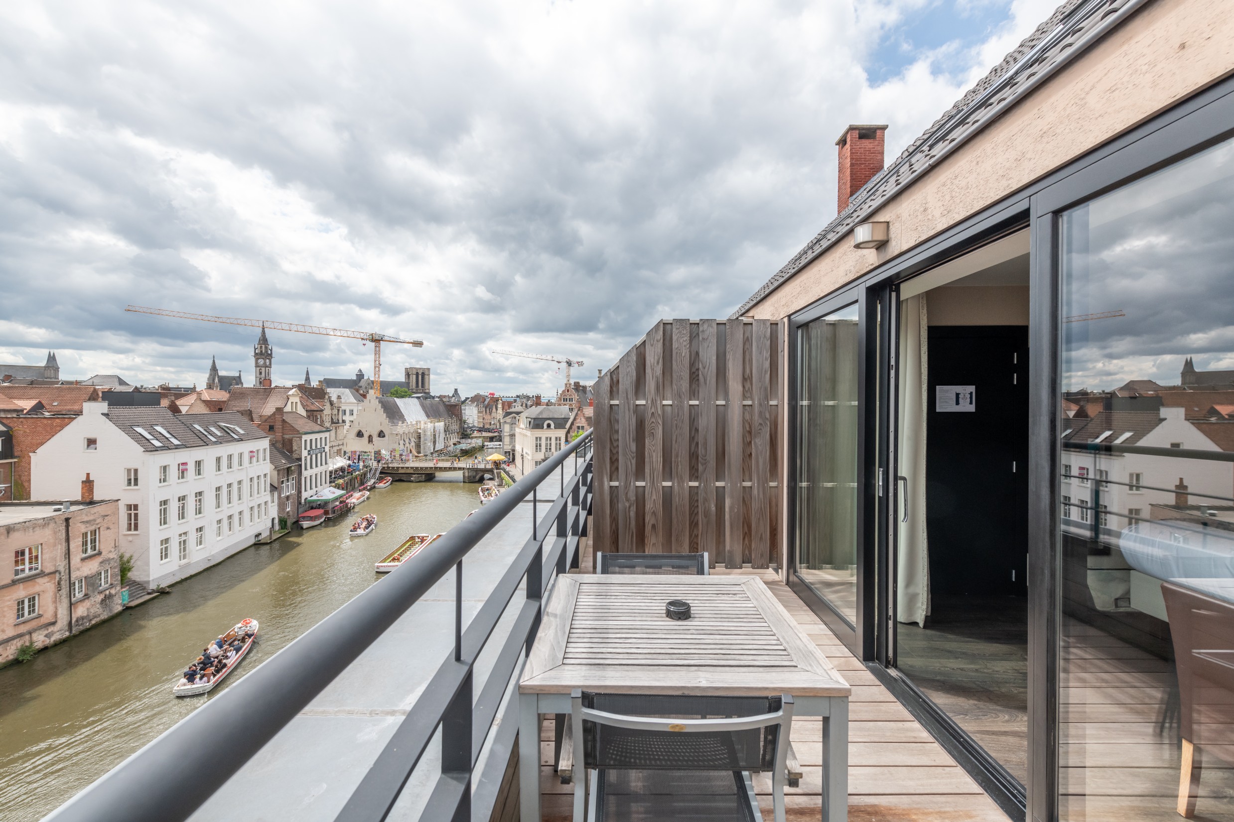 Balkon met uitzicht op de rivier en de torens van Gent