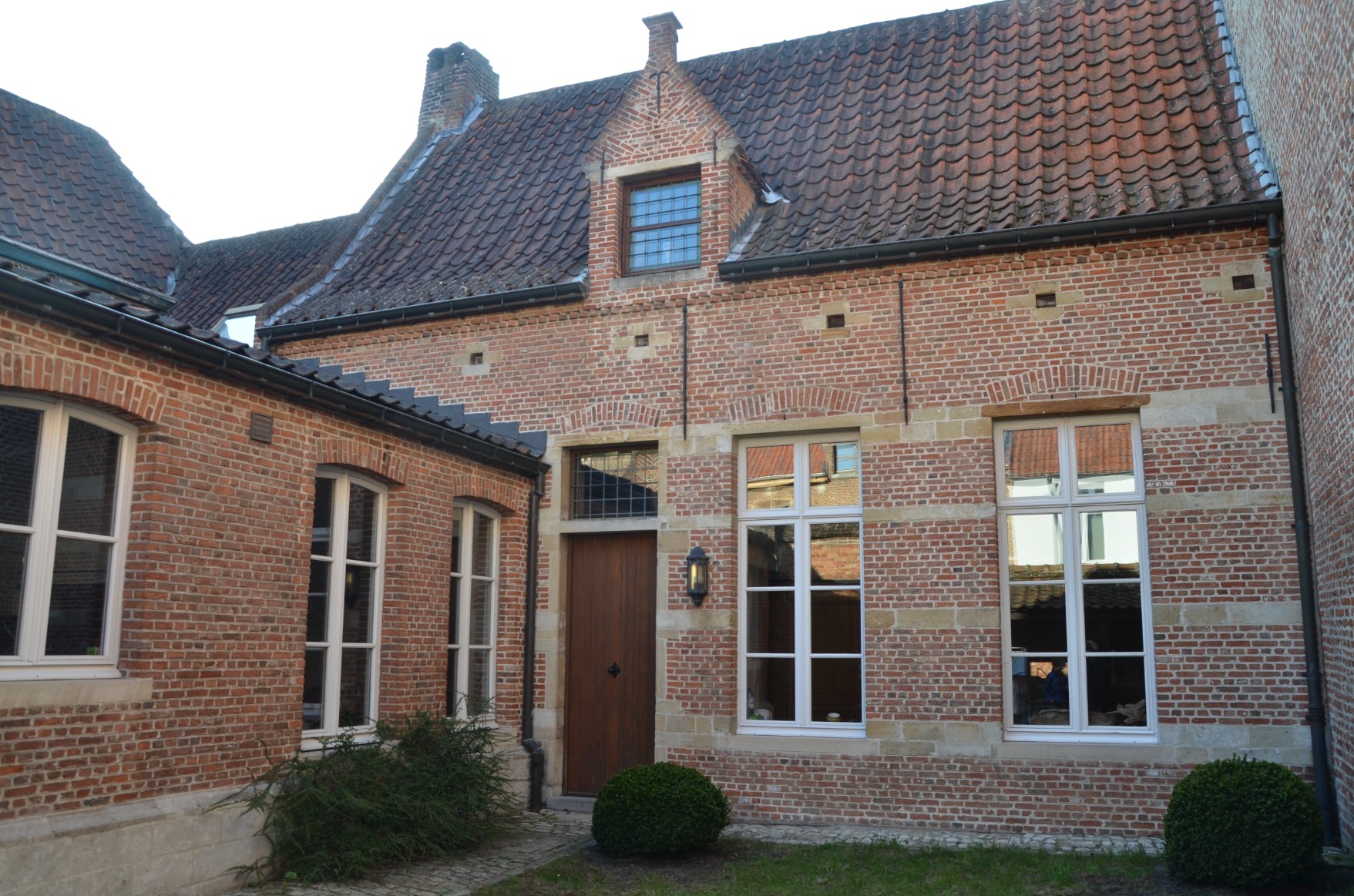 De bakstenen gevel met trapgevel en het binnenplein van De Vrome Vos
