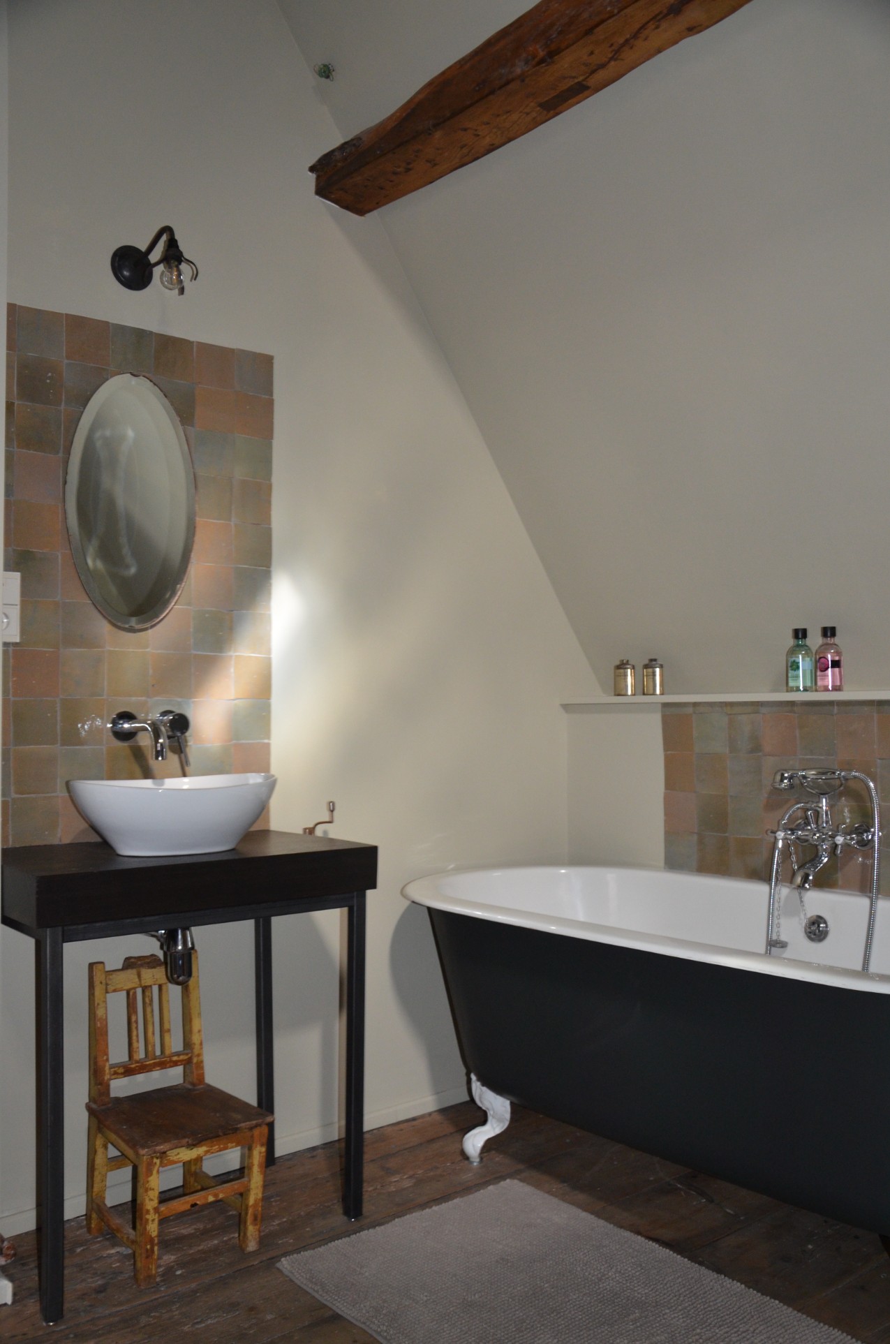 Het zwarte ligbad en de waskom in de badkamer