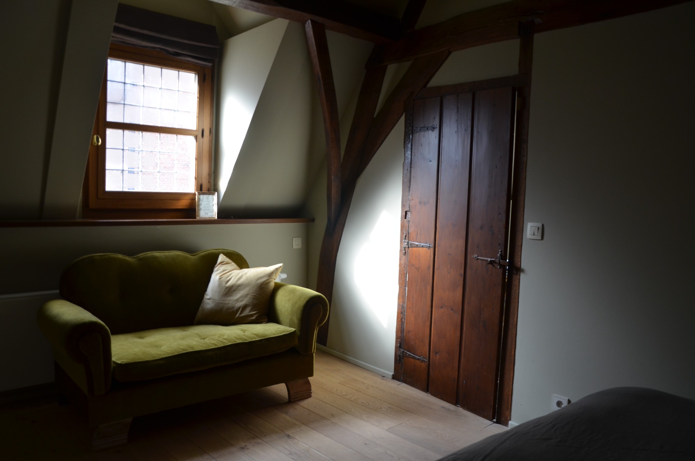 De olijfgroene sofa en de handgemaakte kastdeuren