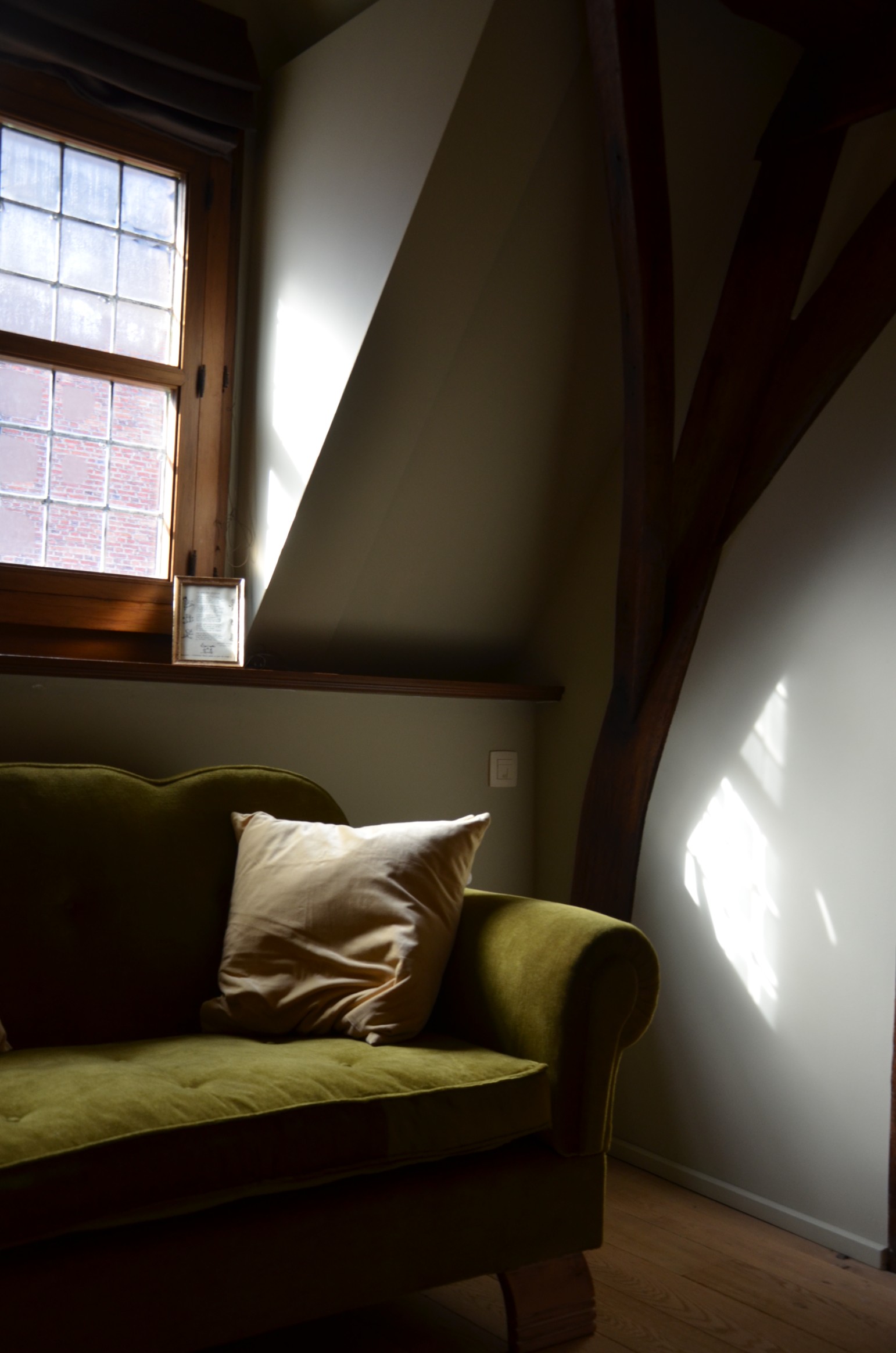 De leeshoek met groene fauteuil in het zonlicht