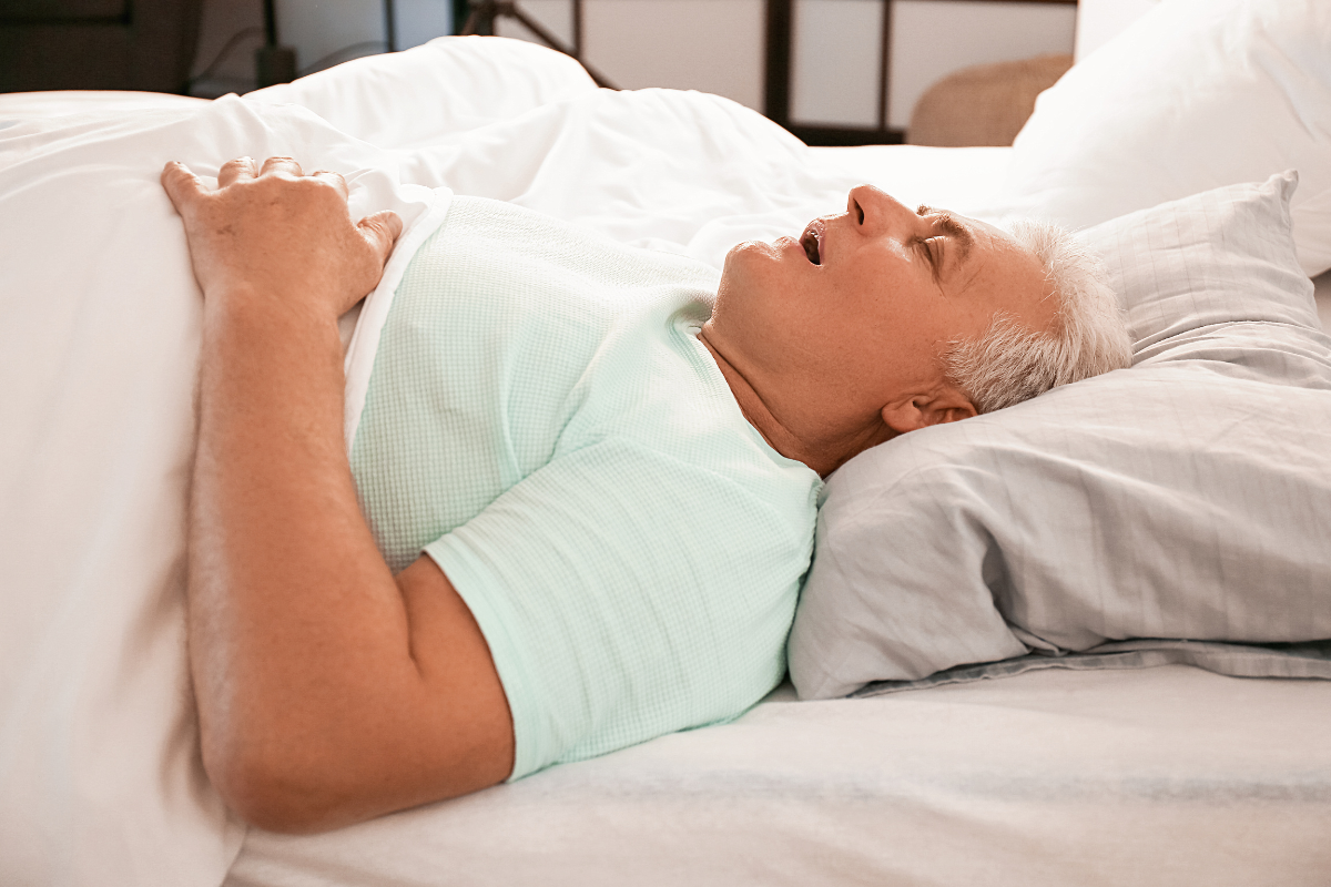 Man sleeping with mouth open while in bed.