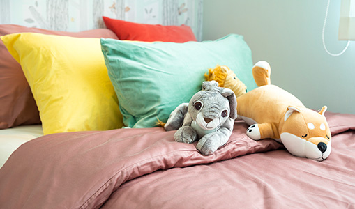child's bed with pillows and stuffed animals