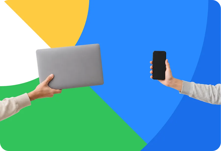 Hands holding a laptop and a phone