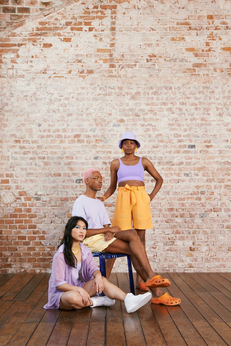 A woman sitting on a chair next to two men photo – Fashion photography Image on Unsplash
