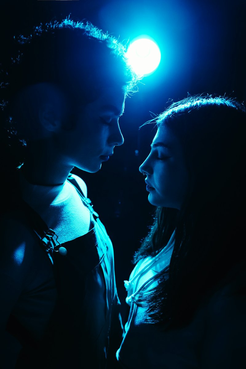 Two people gaze at each other under a blue light. photo ...