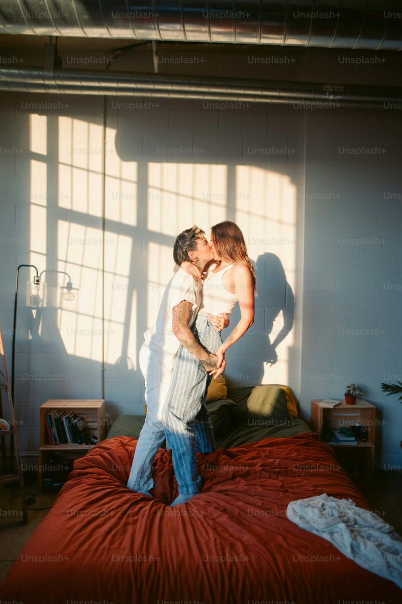 A man and a woman kissing on a bed photo – Portrait Image on ...