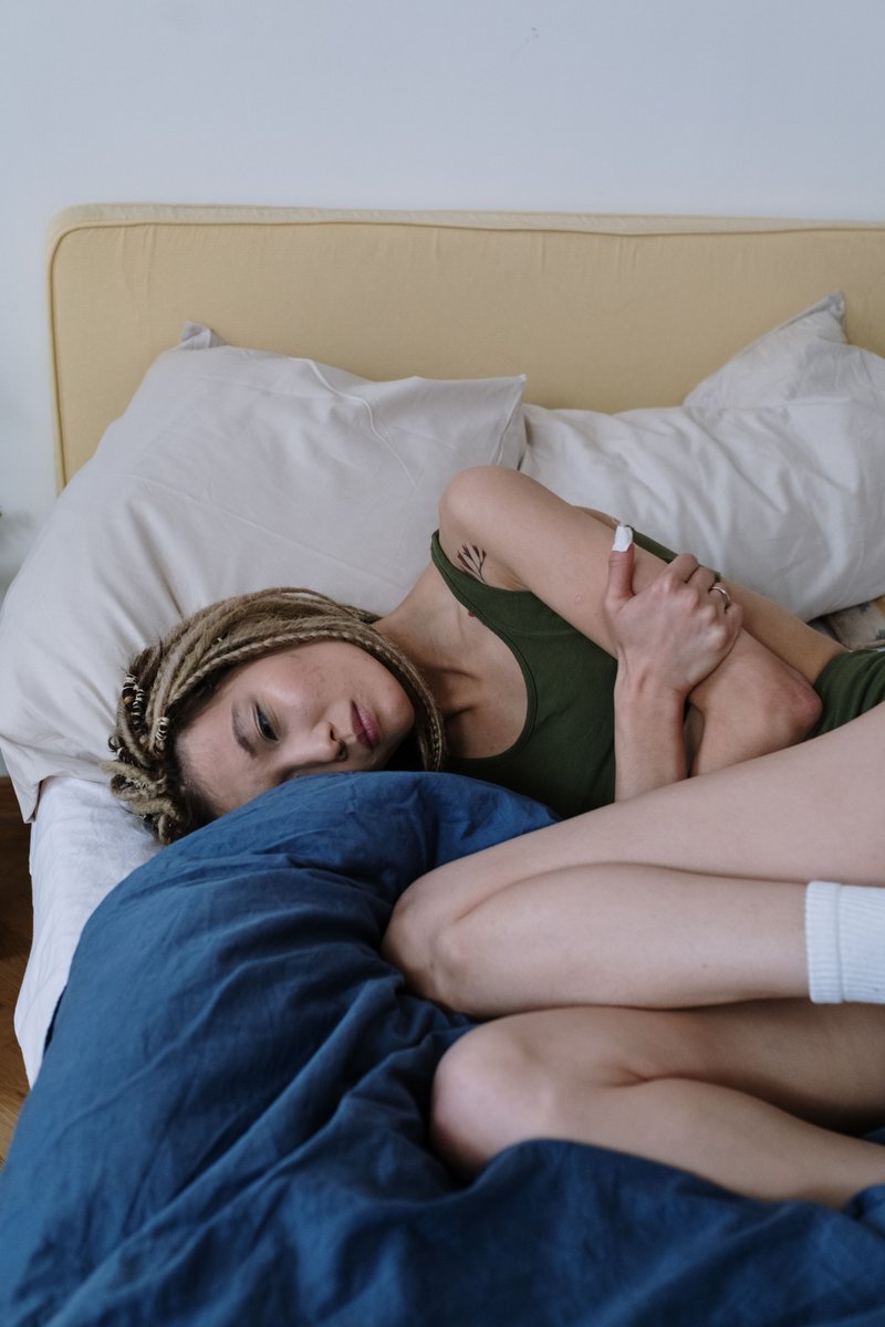 Woman Suffering from a Stomach Pain Lying Down on Bed · Free ...