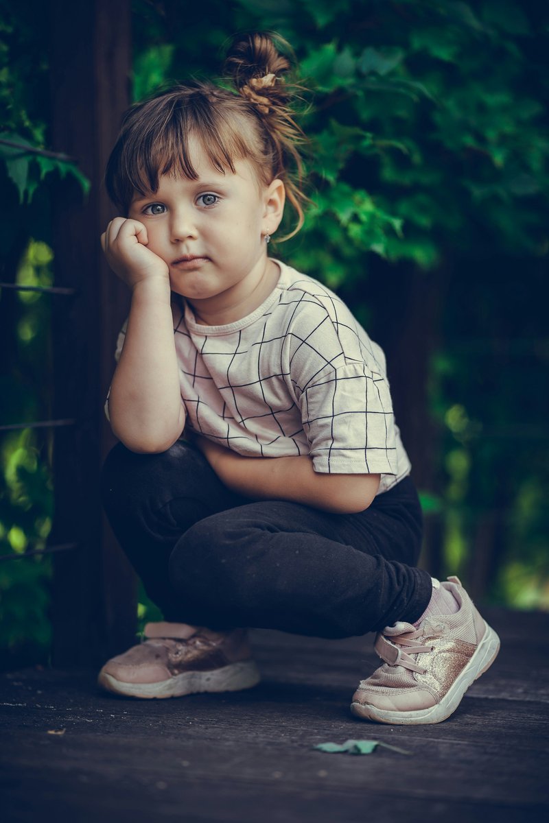 A little girl sitting on the ground with her hand on her face photo – Free Black Image on Unsplash