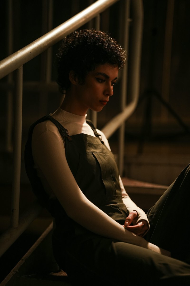 A woman sits alone on some stairs. photo – Free Green Image on Unsplash