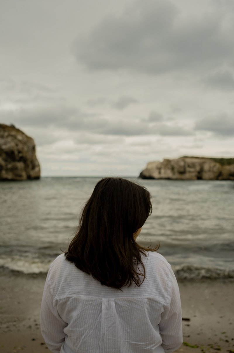Back of a Woman Standing Alone on a Beach · Free Stock Photo