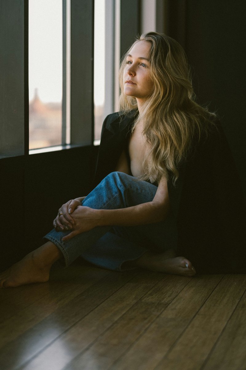 A woman with blonde hair is looking out a window - Free Photo on Unsplash