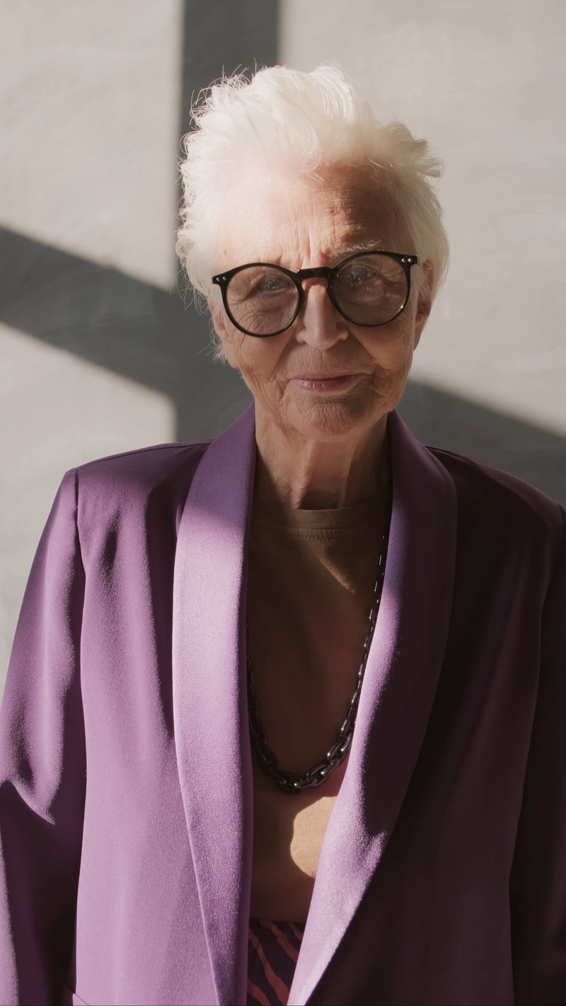 Elderly Woman in Purple Coat Smiling