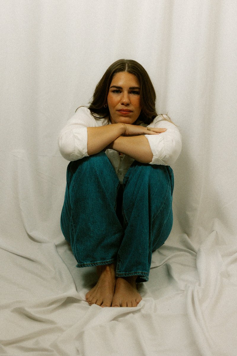 A sad woman sits alone with her arms crossed - Free Photo on Unsplash