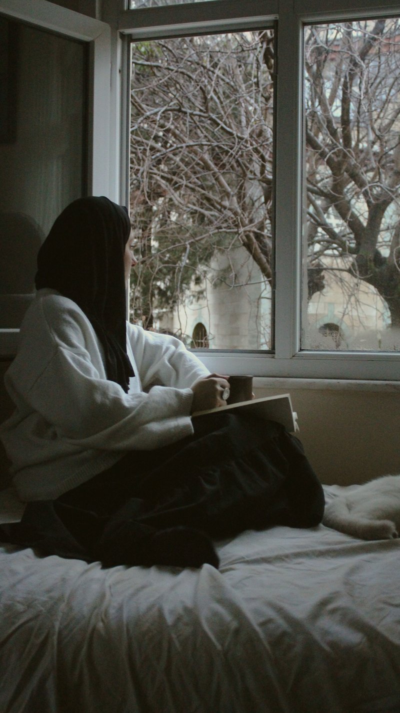 Woman in Hijab Sitting on Bed by Windows · Free Stock Photo