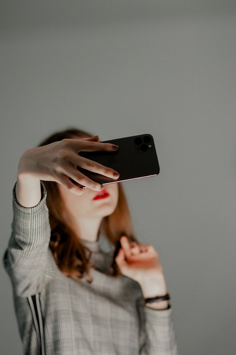 A woman holding a cell phone up to her face - Free Photo on ...