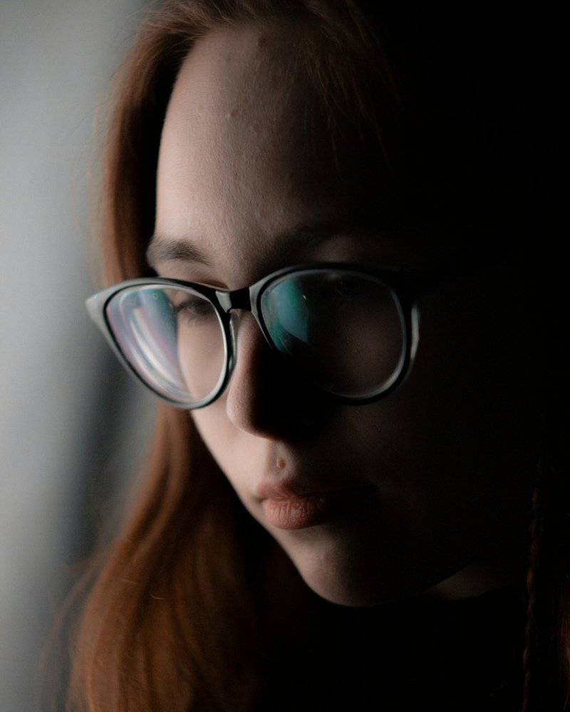 A woman wearing glasses looking down at her cell phone - Free Photo on Unsplash