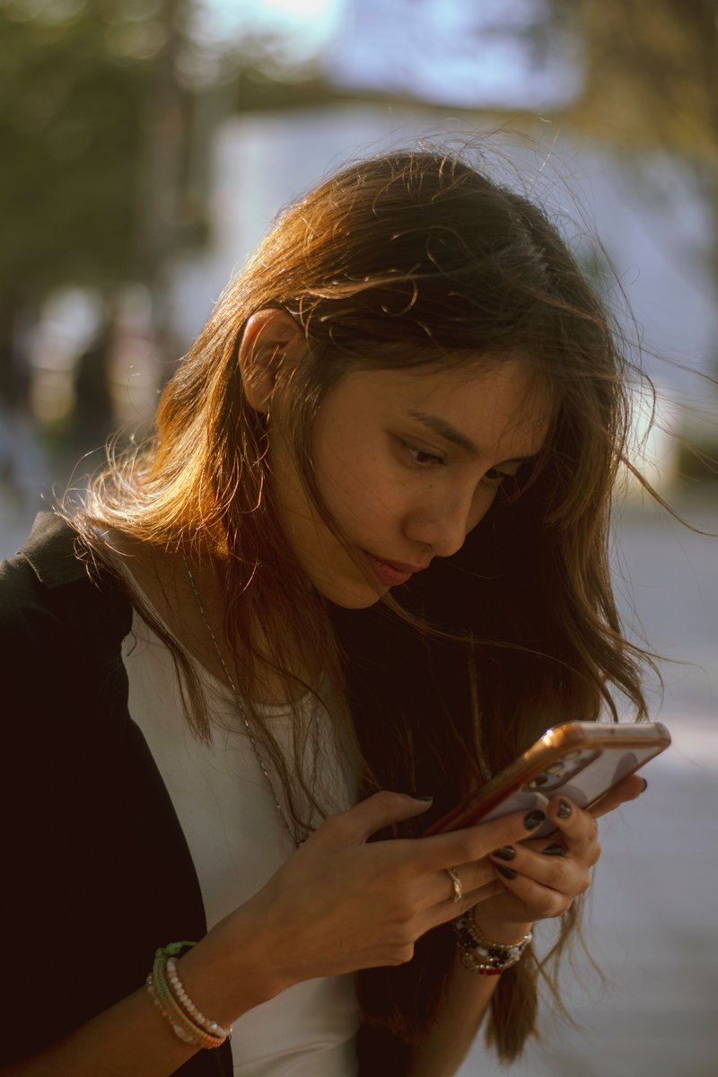 Young Woman Using Smartphone at Bus Stop in Eskişehir · Free Stock Photo