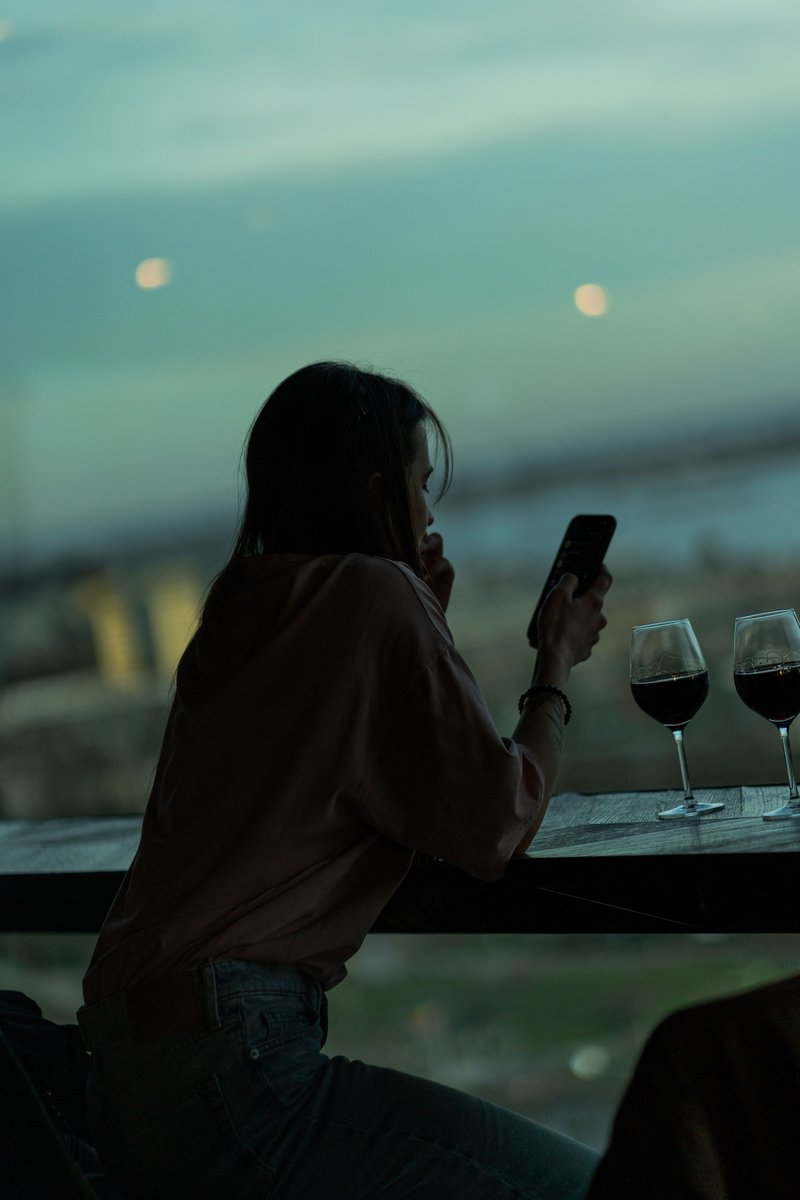 Woman Sitting at the Table by the Window with a Glass of ...