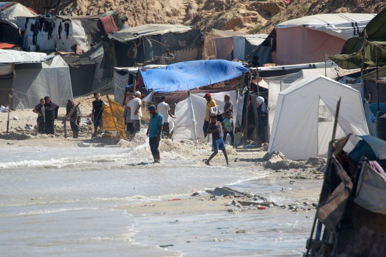 In Pictures: Palestinians clear out their flooded tents on Khan Younis beach after being inundated by high tides