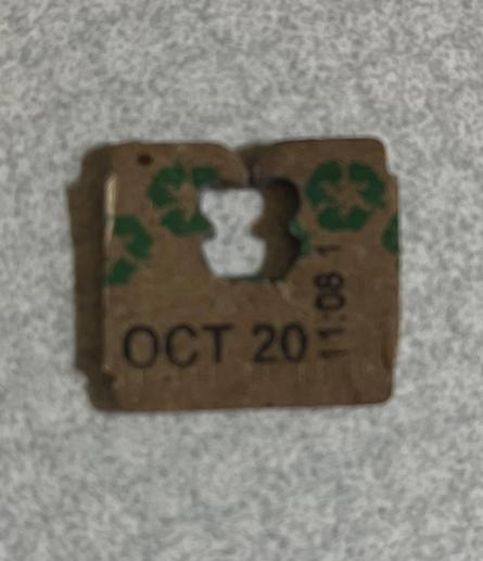 a cardboard occlupanid freed from its wrapper; it is adorned with green recycle symbols and a date of “oct 20”
