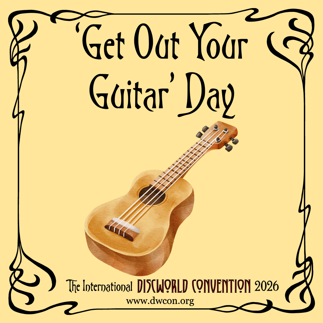 Black text on a pale yellow background with a swirly border, reading 'Get Out Your Guitar Day'. There is also a drawing of a brown acoustic guitar.
