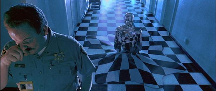 the T1000 morphs up from a checkerboard floor, a silvery vaguely man-shaped torso above a skirt of distorted fake floor tiles; in the foreground a guard rubs his face