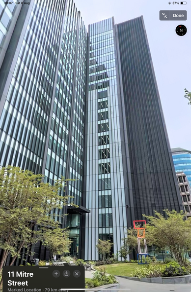looking up at the tower block from mitre square, it’s mostly clad with greenish grey windows except for a tall narrow section covered in black louvres 