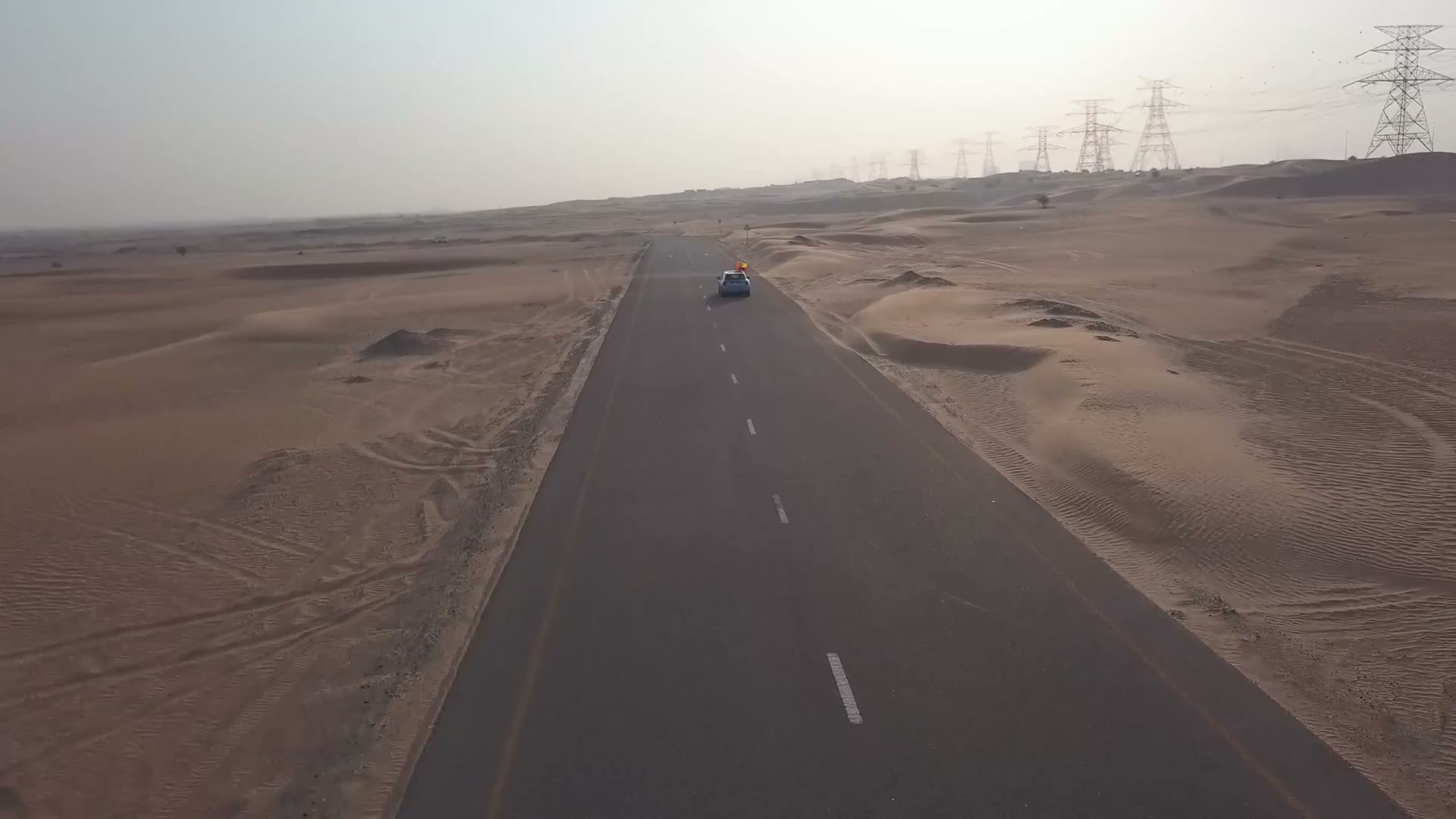 Aerial drone view of a vehicle on a desert road