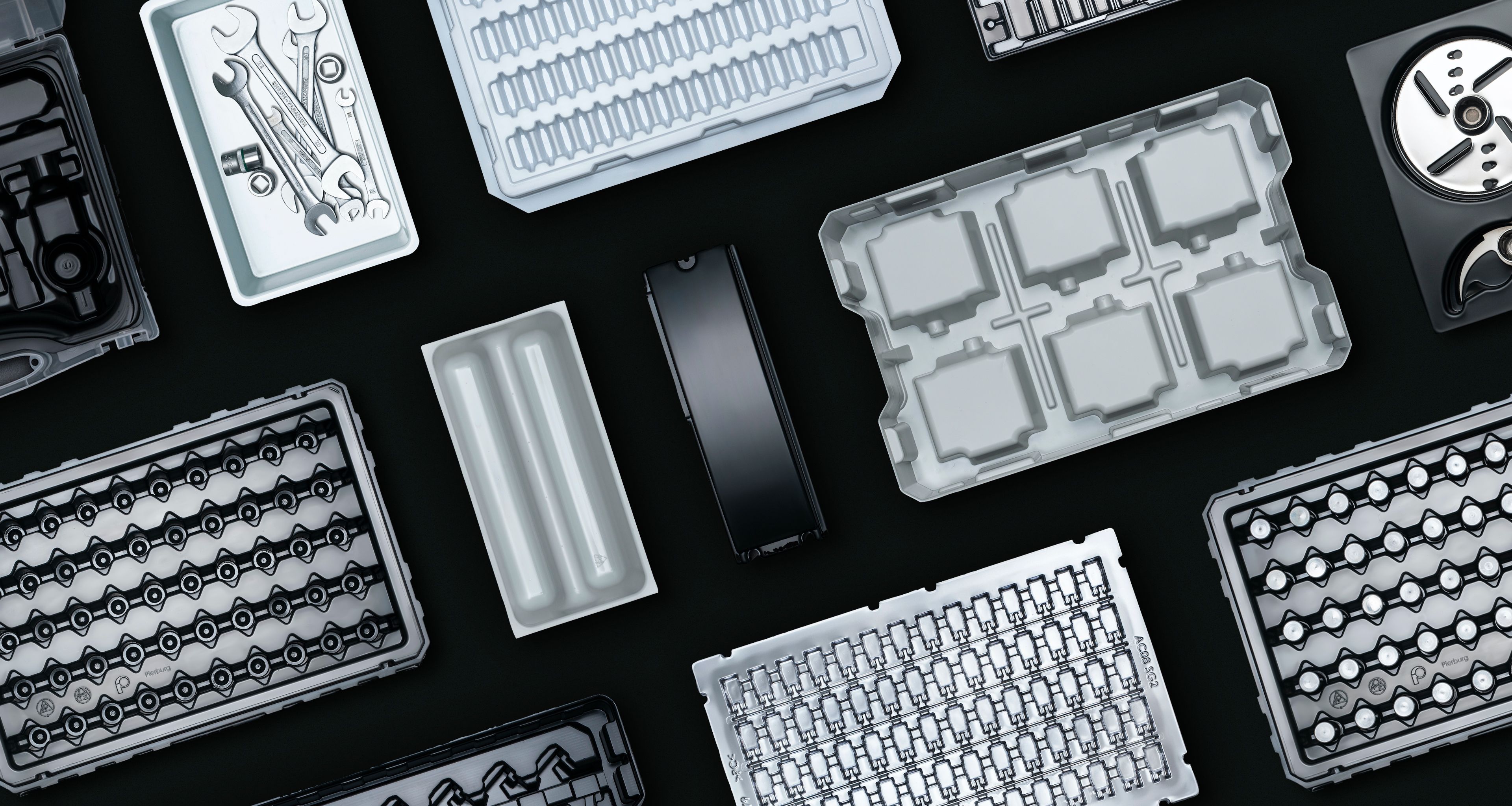 Tiefziehteile in verschiedenen Variationen vor einem schwarzen Hintergrund