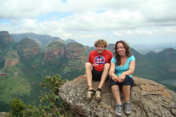 een koppel zit op een rots op een hoog uitzichtpunt van de Blyde River Canyon