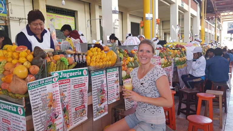 reiziger bij een kraam met sapjes in de stad cusco