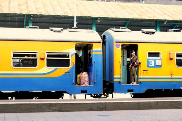 Mensen staan bij deur van een rijdende trein op Java