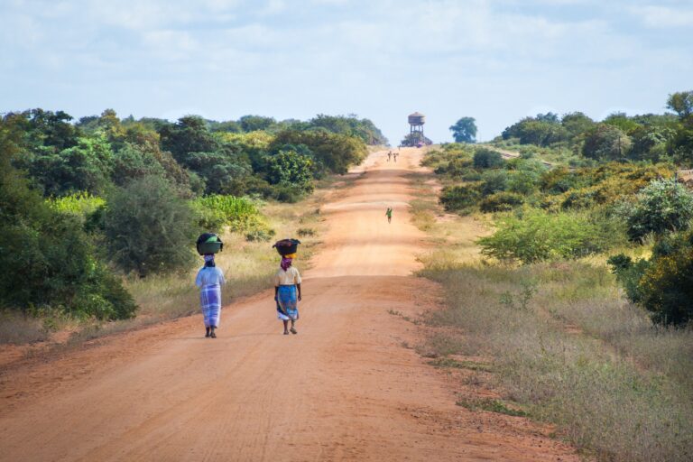 twee Afrikaanse vrouwen lopen over een zandpad