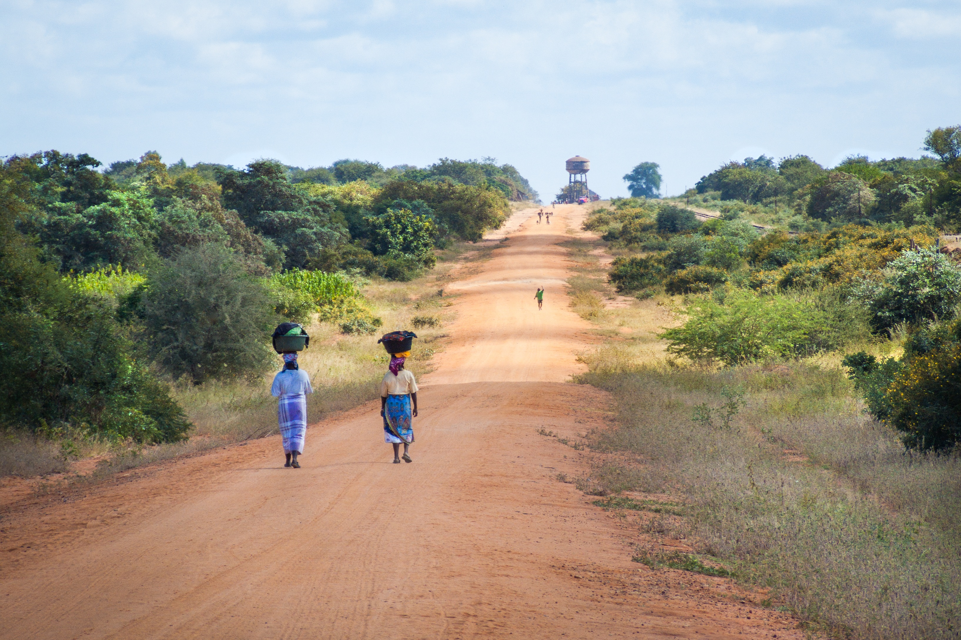 twee Afrikaanse vrouwen lopen over een zandpad